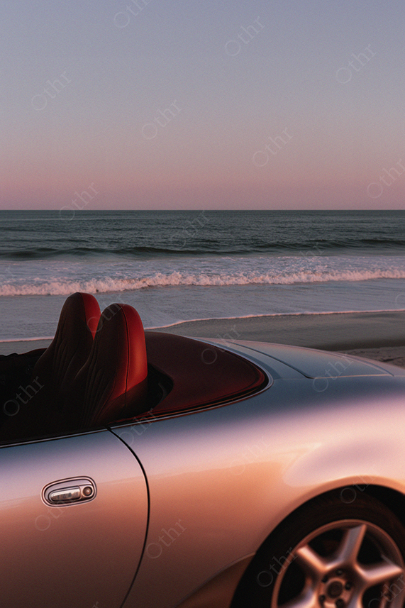 Convertible Parked by Ocean at Sunset