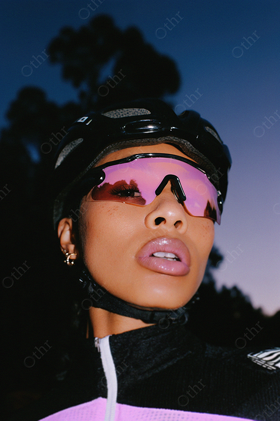 Portrait of a Cyclist in Black and Pink Sportswear with Reflective Glasses at Dusk