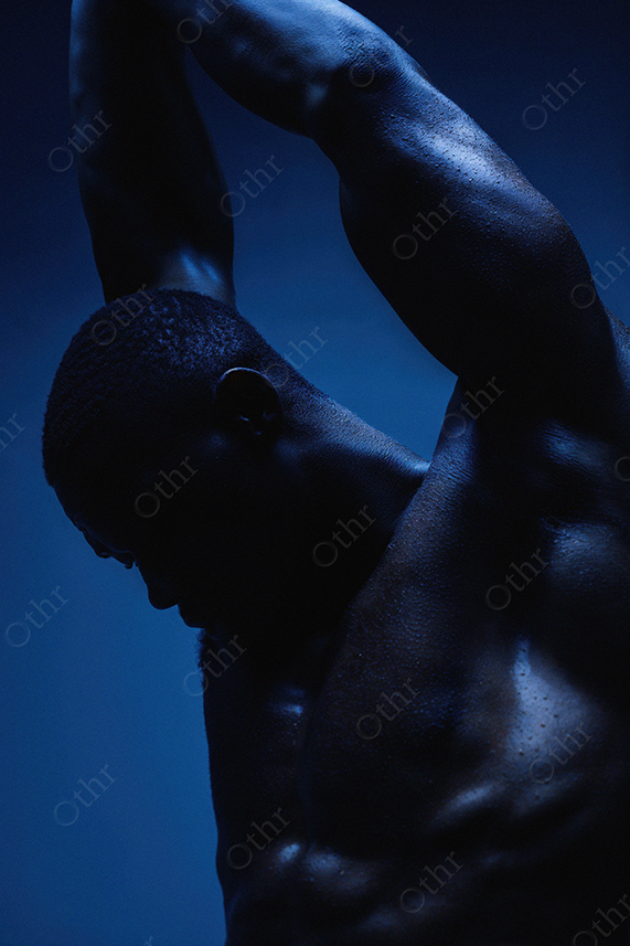 Muscular Male Silhouette Under Dramatic Blue Lighting