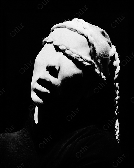 Sculptural Face with Braided Hair Covering Eyes in Dramatic Lighting – Black and White