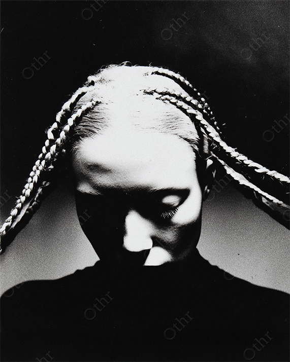 Portrait of Woman with Braided Hair Fanned Out in Dramatic Light – Monochrome