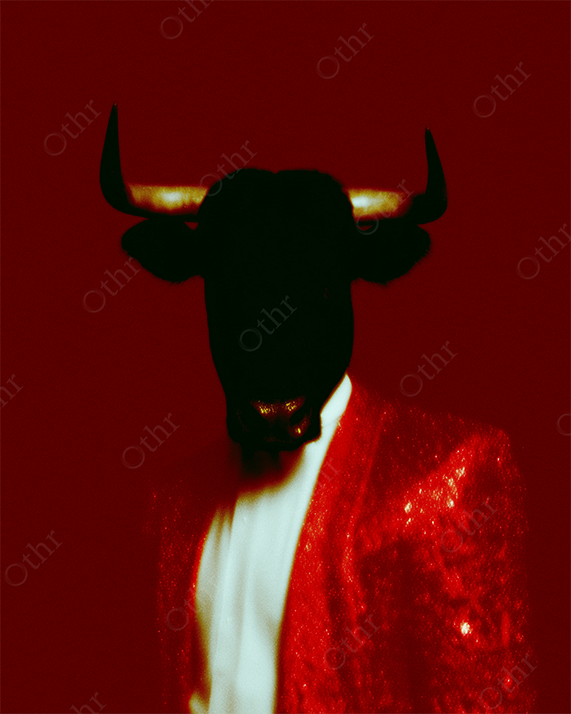 Bull-Headed Figure in Red Glitter Jacket Against Solid Red Background – Surreal Portrait