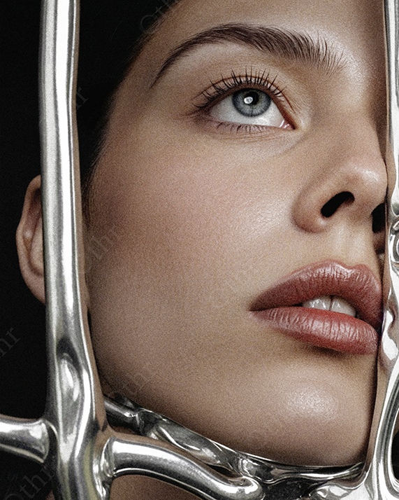 Close-Up Portrait of Woman with Blue Eyes Behind Sculpted Metallic Frame