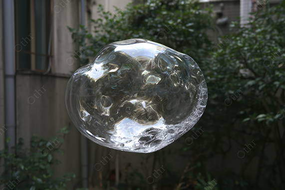 Distorted Transparent Soap Bubble With White Foam Floating Outdoors Near Green Foliage