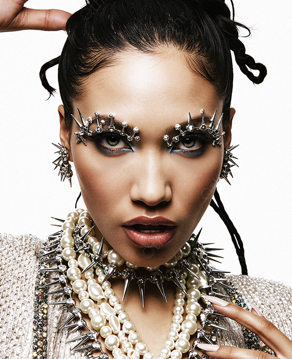 Close-Up Portrait of a Person With Spiked Jewellery, Pearls and Embellished Eyebrows