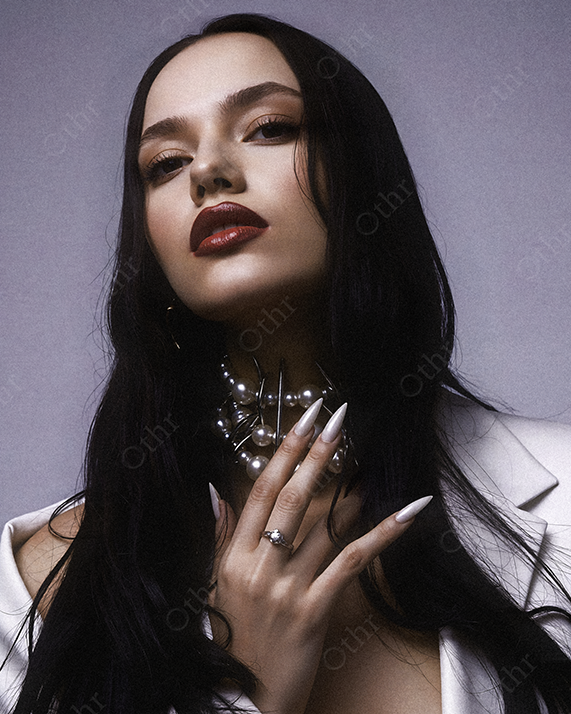 Portrait of a Person in White Blazer With Dark Hair, Pearl Choker and Long Nails