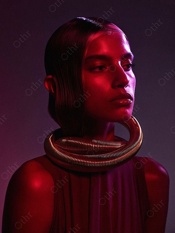 Studio Portrait of a Person With Metallic Coil Necklace in Red and Purple Lighting