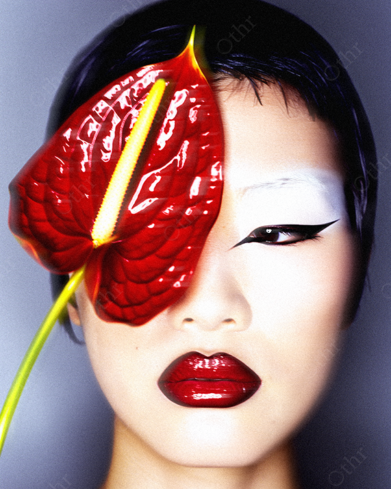 Close-Up Portrait of a Person With Red Anthurium Flower and Graphic Makeup