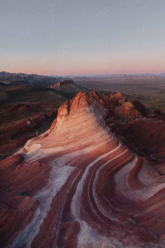 Striped Red Rock Formation in Desert Landscape at Sunset