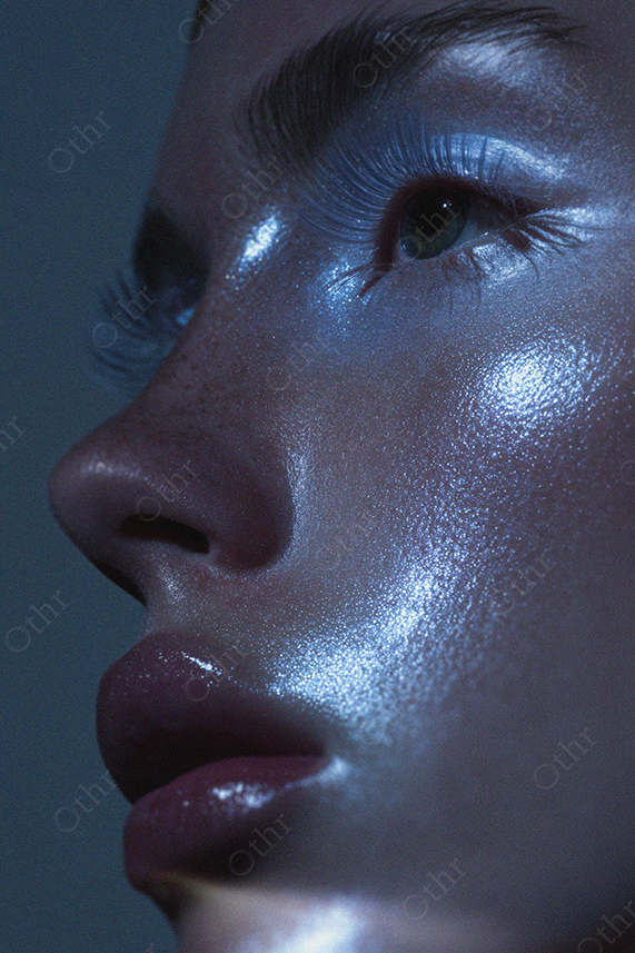 Close-Up Portrait of Face With Shiny Skin and Long Eyelashes in Blue Light