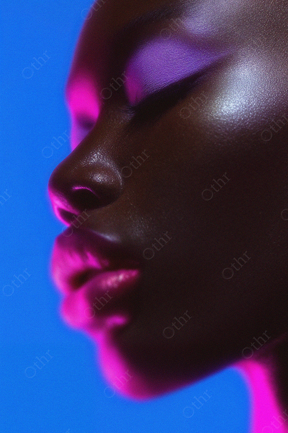 Side Profile of Woman With Pink and Purple Neon Light on Face
