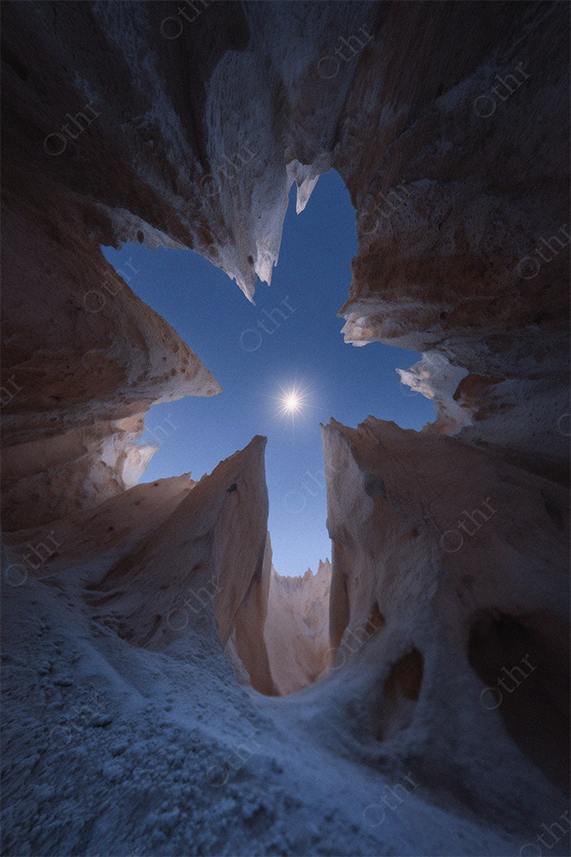View of Moon Through Jagged Rock Formations at Night