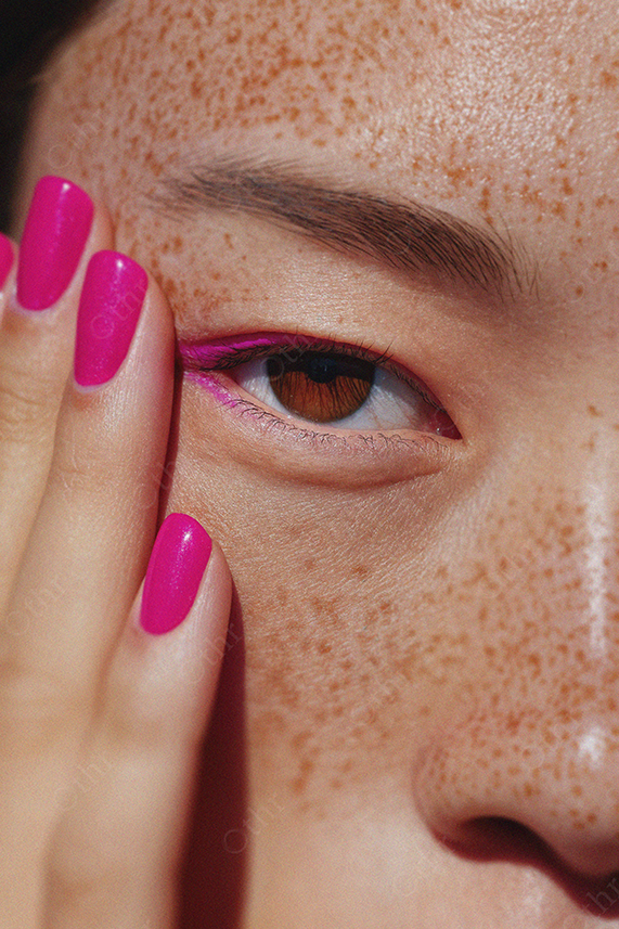 Close-Up of Freckled Face With Pink Eyeliner and Matching Nails