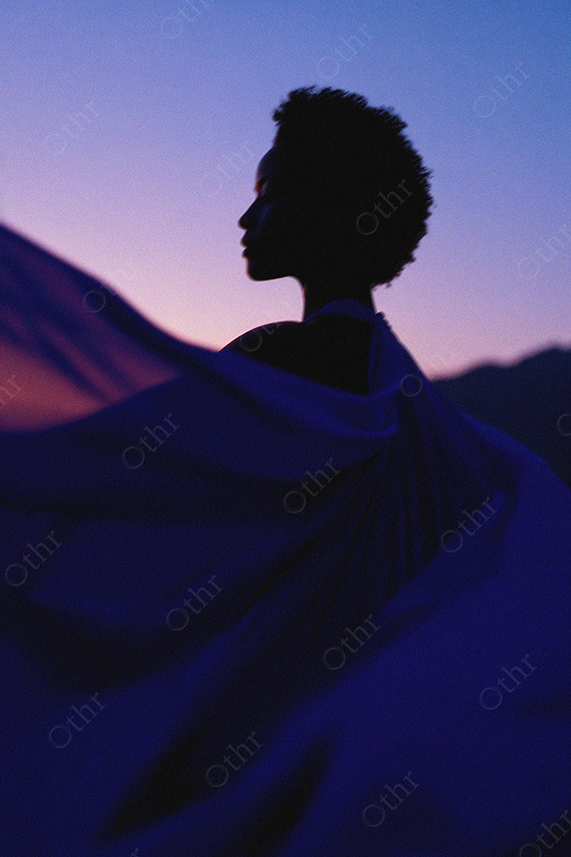 Silhouette of Woman With Flowing Fabric Against Twilight Sky