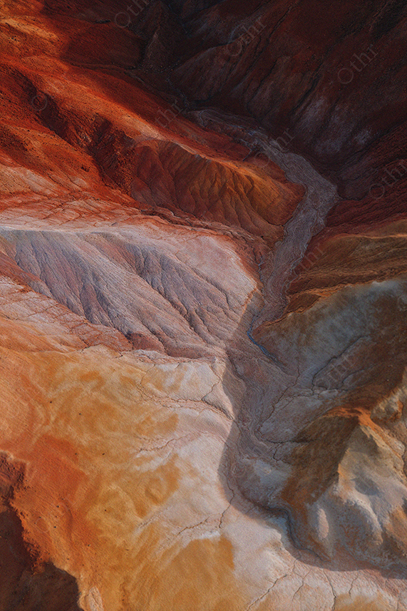 Aerial View of Colourful Layered Rock Formations in Desert Landscape
