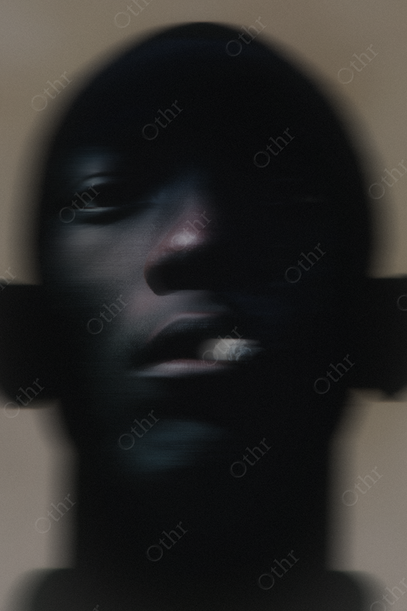 Obscured male figure smoking a cigarette.