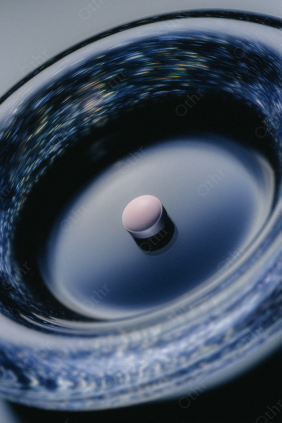 Pink pill on reflective glass ashtray.