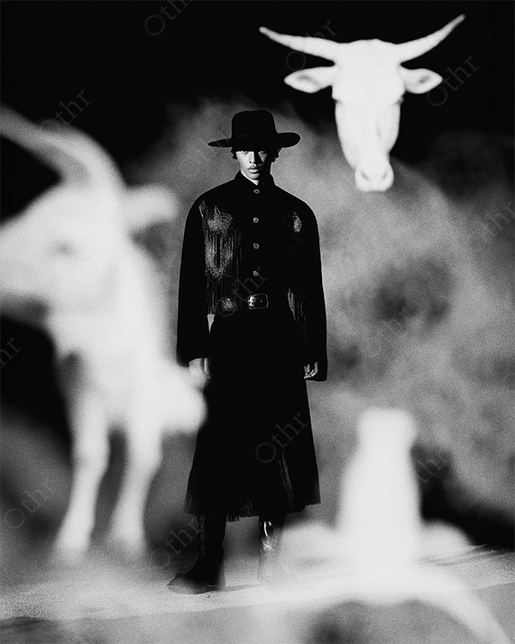 Monochrome cowboy surrounded by ghostly bulls.