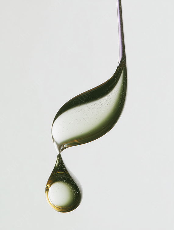 Golden Oil Drop Suspended Mid-Air on White Background