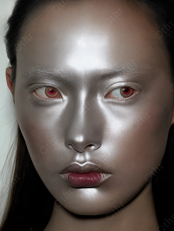 Portrait of a woman with silver makeup and red irises.