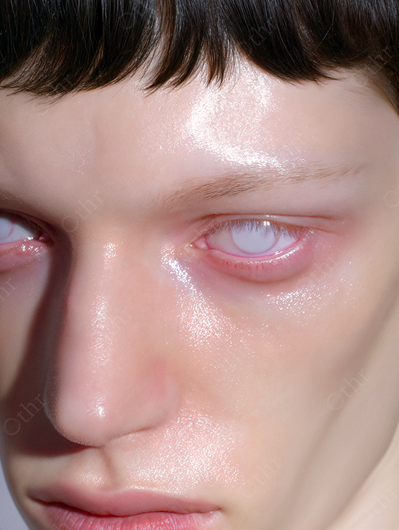 Glossy portrait of a person with opalescent eyes and pale skin.