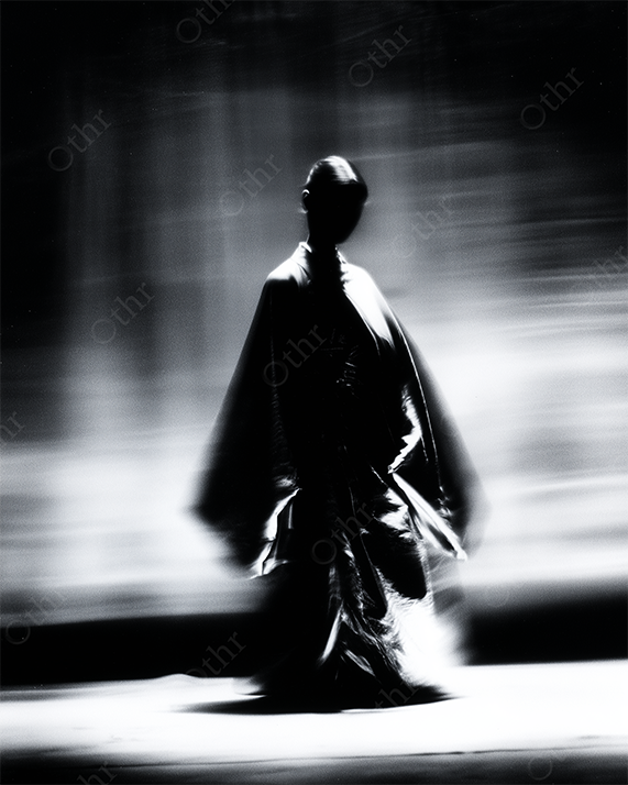 Silhouetted Figure In Flowing Robe Walking In Motion Blur