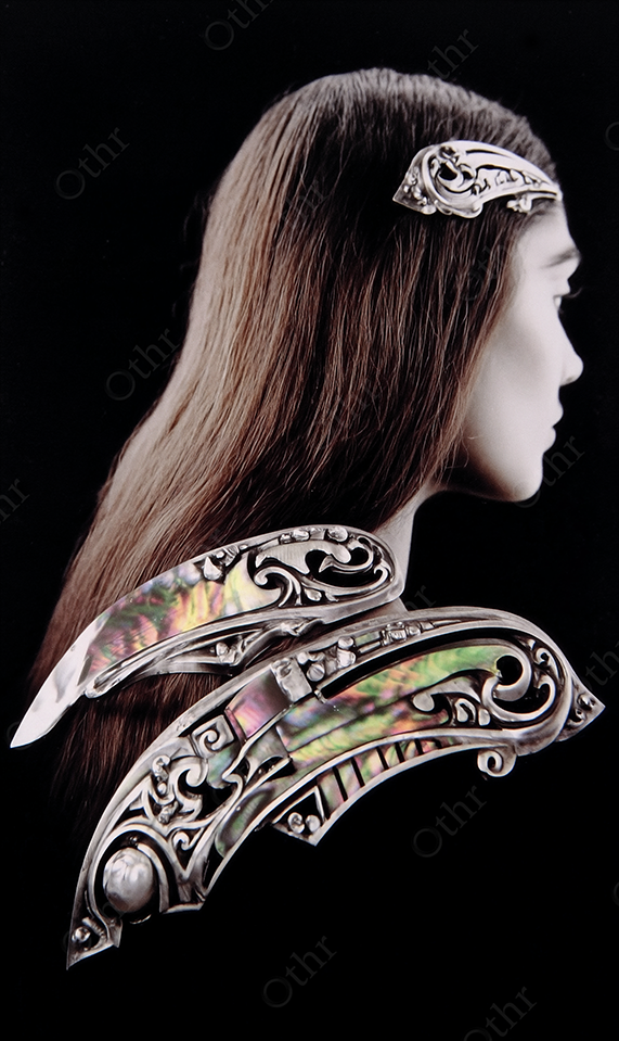 Woman With Decorative Metallic Head Adornment Over Brown Hair, Against Black Background