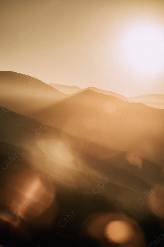 Sunset over sand dunes with golden haze
