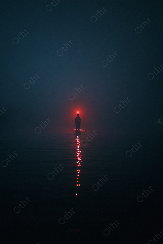 Single red light over a person in the ocean at night