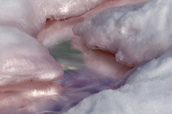 Melted Snow Forming Pink and Green Reflective Pool With Crystalline Edges – Close-Up