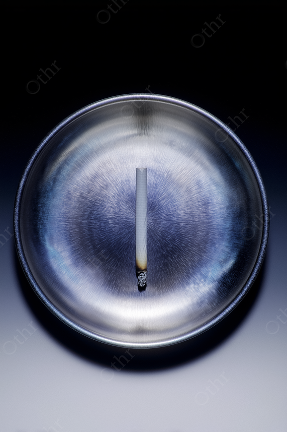 Burning Rolled Cigarette in Metallic Ashtray