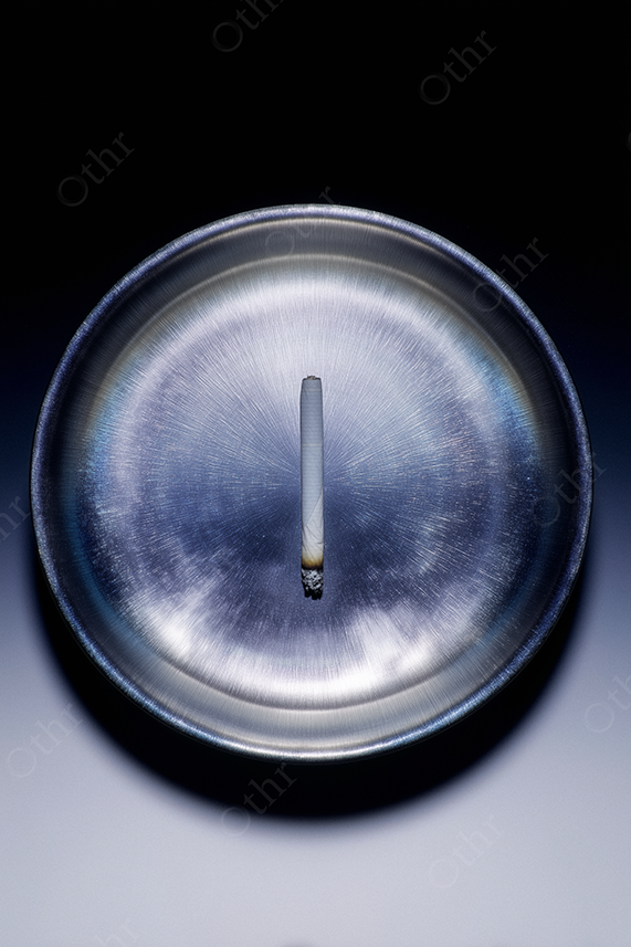 Burning Rolled Cigarette in Metallic Ashtray