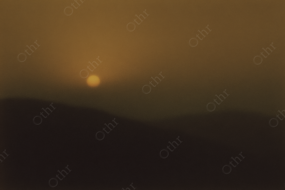 Blurry Sunset Over Rolling Hills With Soft Golden Haze