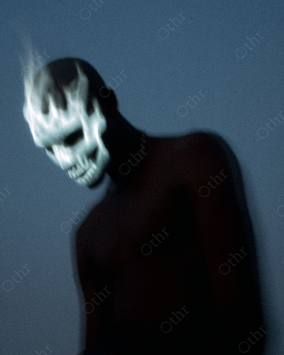 Dark Silhouette of Person with Glowing Flame Skull Mask at Dusk