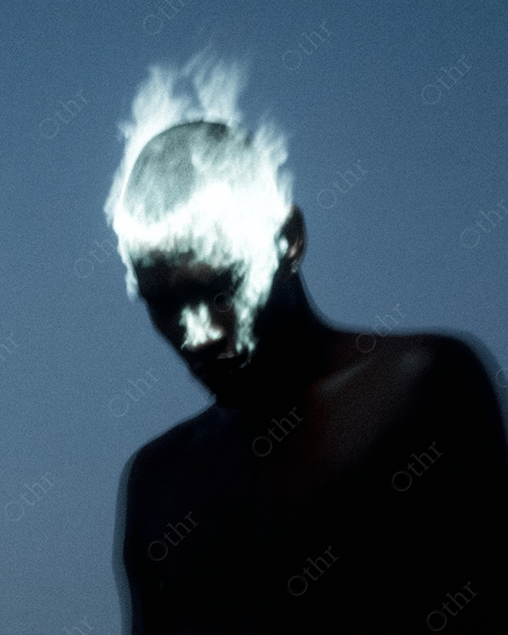 Shirtless Person with Glowing Flame-Like Hair and Shadowed Face