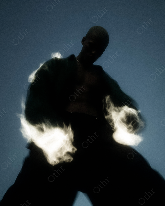 Low-Angle Silhouette of Person with Flames Erupting From Sleeves