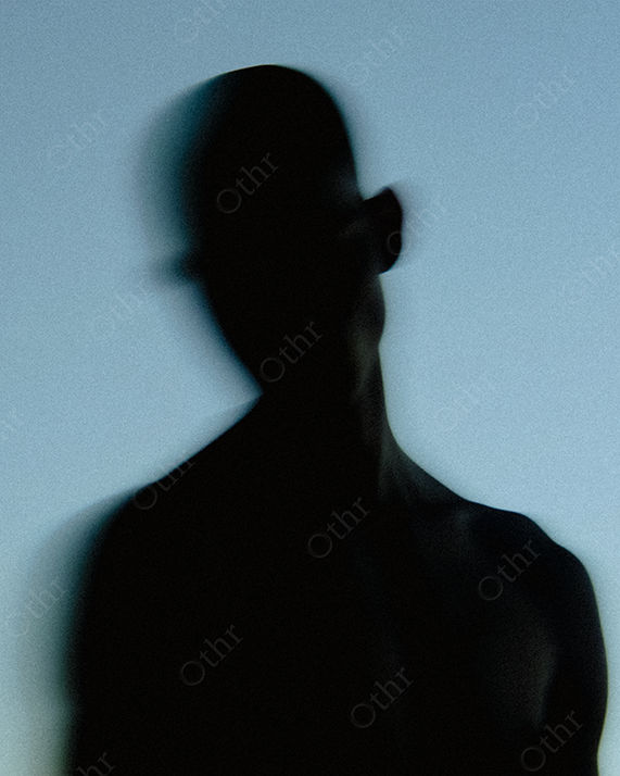 Silhouetted Person with Blurred Head Against Blue Gradient Background
