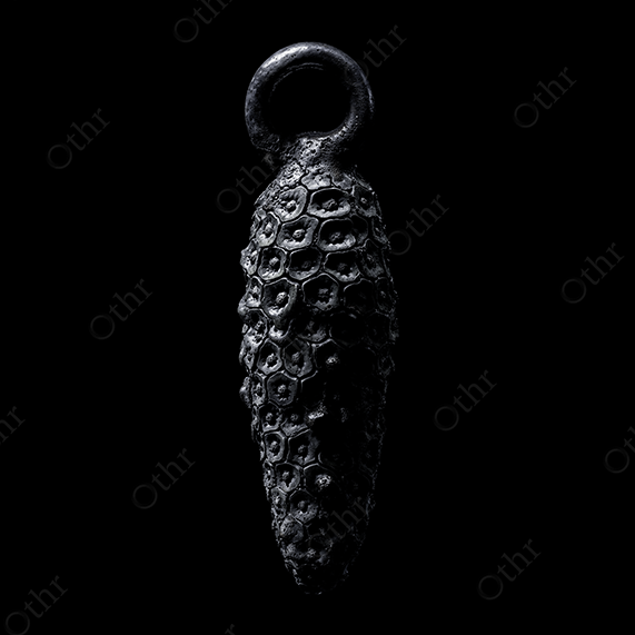 Metallic Monstera Fruit Pendant on Black Background – Still Life