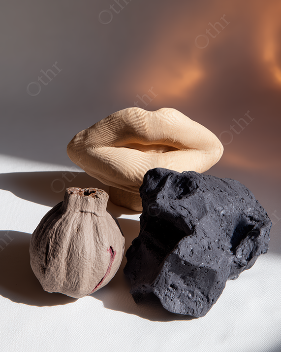 Still Life Composition With Clay Lips Sculpture and Textured Stones in Warm Light
