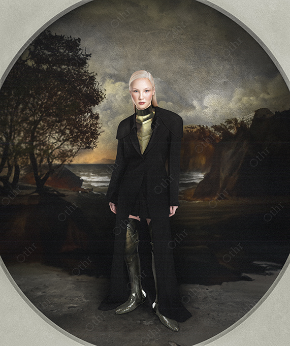Portrait of Woman in Black Coat and Metallic Armour Standing Before Dramatic Coastal Landscape