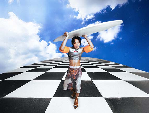 Person in Futuristic Outfit Carrying White Board on Checkerboard Pathway Under Blue Sky