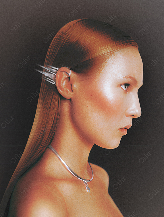 Side Profile of Woman With Metallic Hair Clip and Silver Necklace Against Dark Gradient Background
