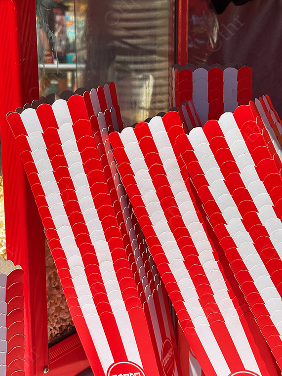 Stack of Red and White Popcorn Boxes Beside Popcorn Machine