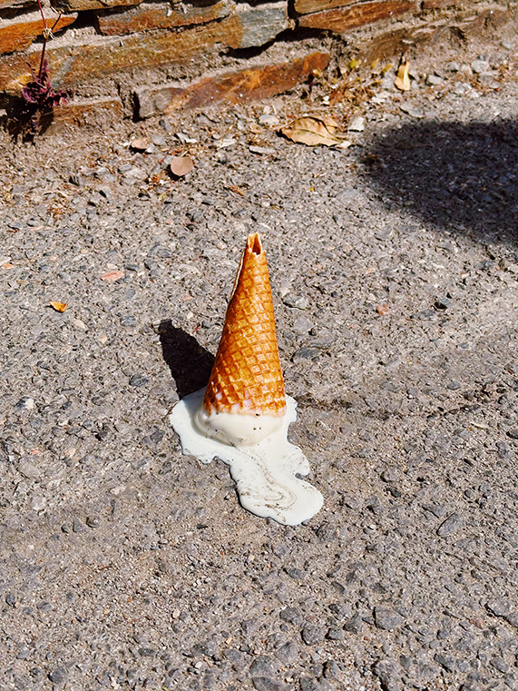 Dropped Ice Cream Cone Melting on Pavement in Sunlight