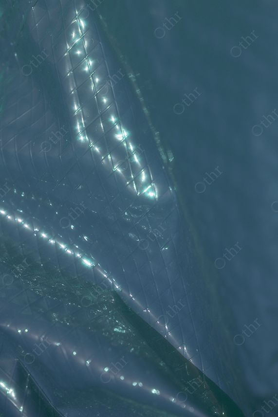 Close-Up of Reflective Quilted Surface in Soft Blue-Green Light