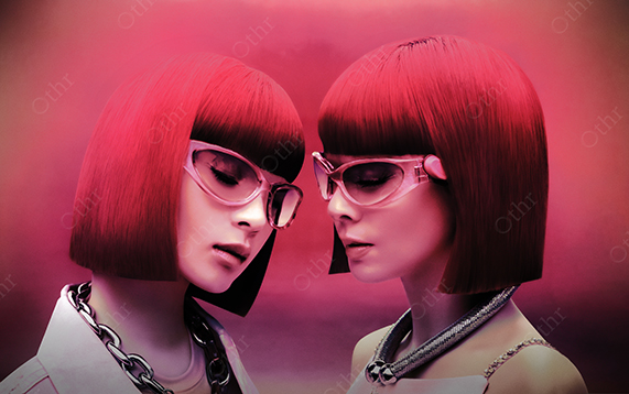 Two People With Red Bob Haircuts and Pink Glasses Against a Soft Magenta Background