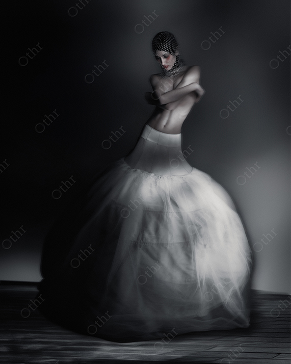 Person in Voluminous White Skirt and Mesh Headpiece Standing in Dark Moody Studio Light