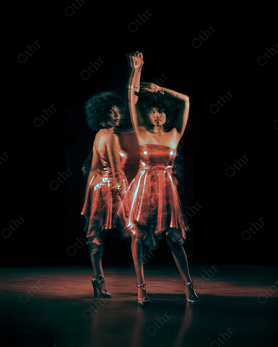 Dancer in Shimmering Red Dress With Motion Blur Against Dark Stage Background