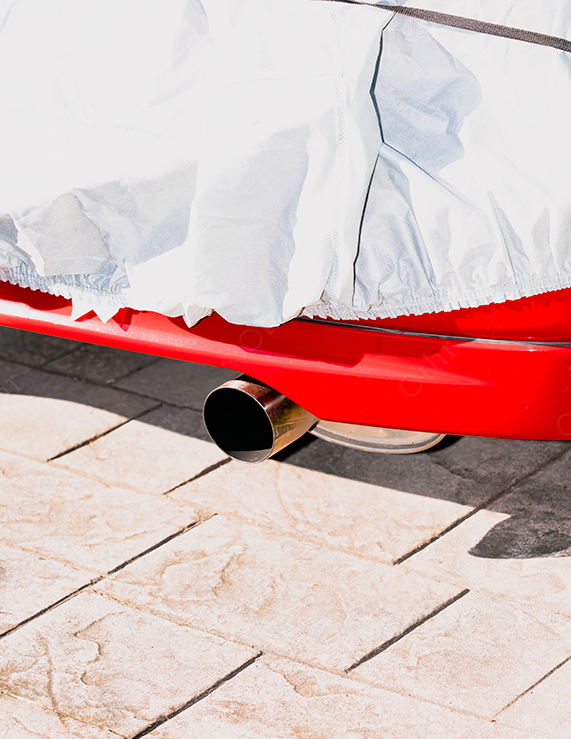 Car Exhaust Pipe Extending Below Red Bumper Beside Stone Pavers