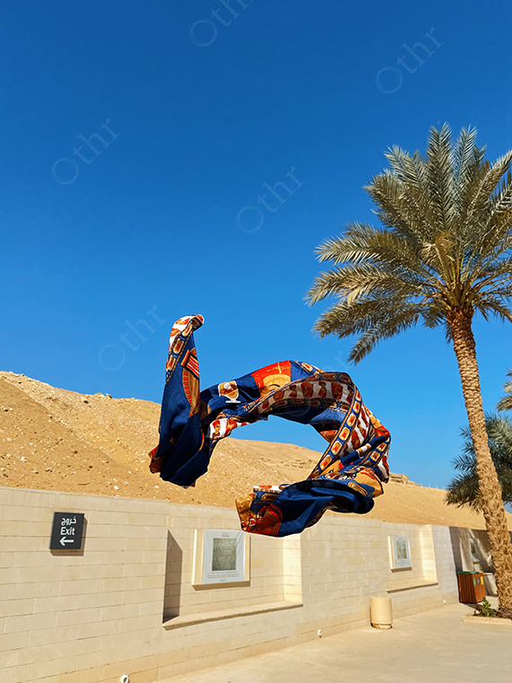Patterned Scarf Floating in Air Under Clear Blue Sky